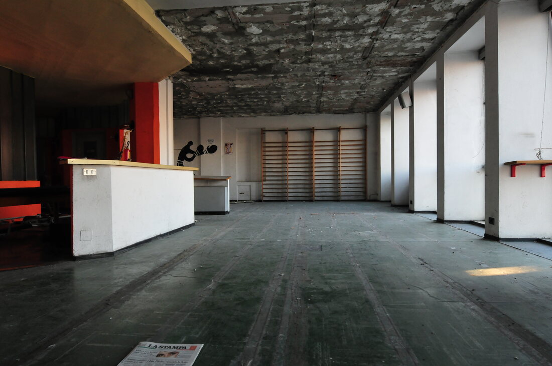 Una sala vuota e danneggiata della prima sede